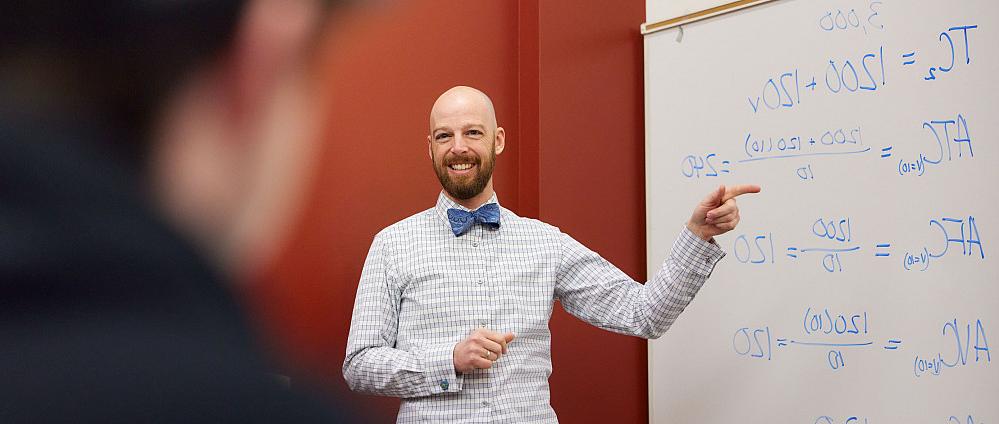 Professor Erik Johnson teaching in front of a whiteboard.